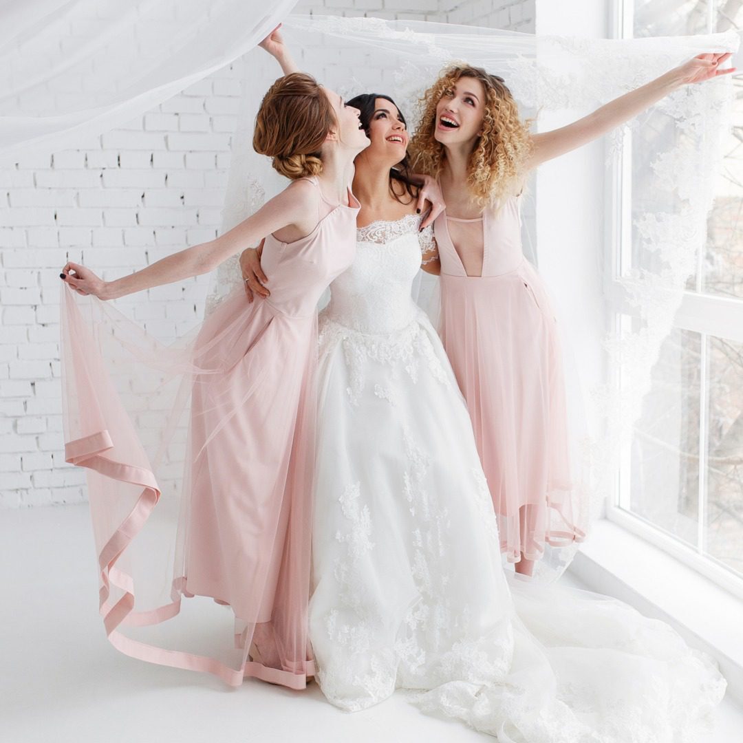 A group of women in pink dresses posing for the camera.